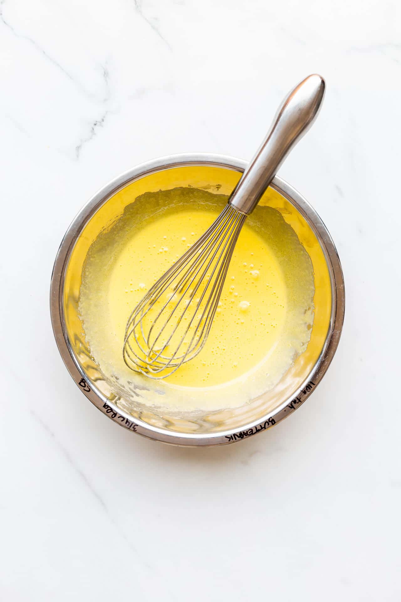 Egg yolks whisked with sugar until they lighten in colour so that they are a creamy light yellow in stainless steel bowl