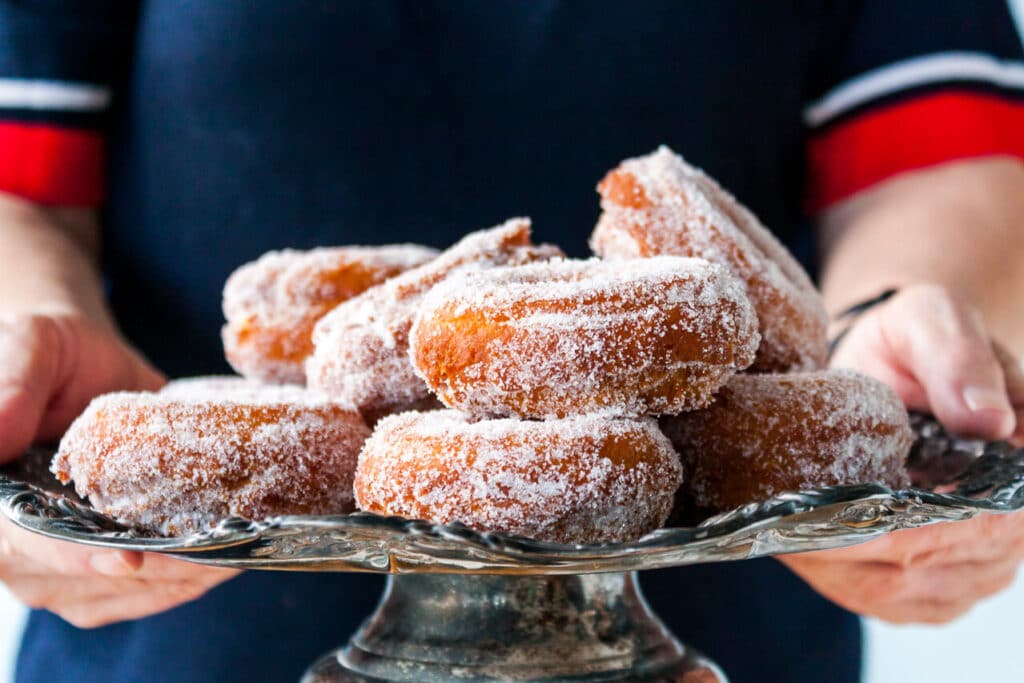 Sugar coated donuts piled on a cake stand