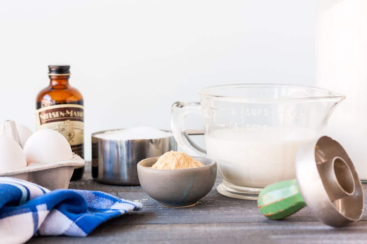 Ingredients for baking powder donuts include milk, flour, vanilla, eggs, and spices like ground ginger shown here