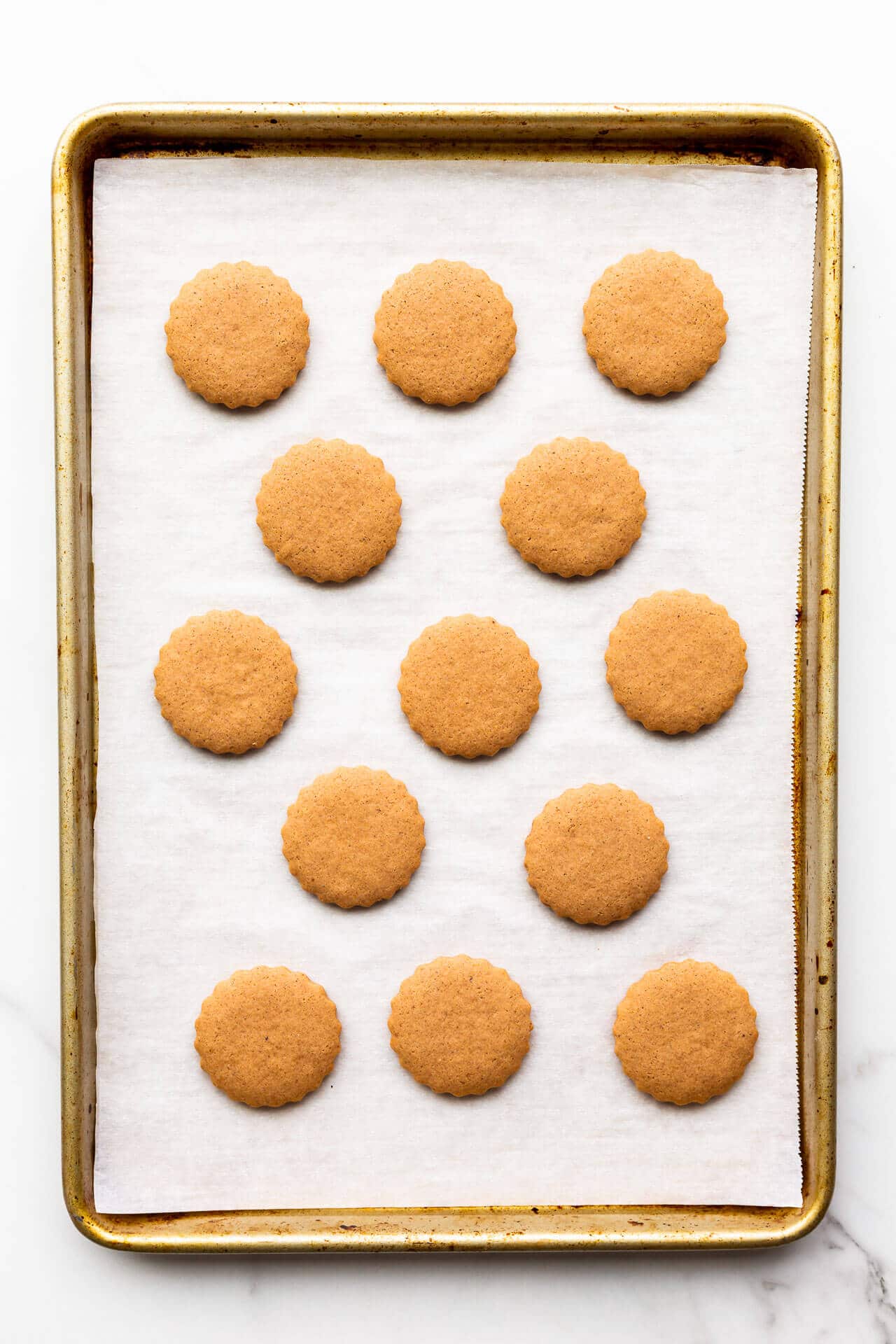 Freshly baked German gingerbread cookies on a parchment lined sheet pan.