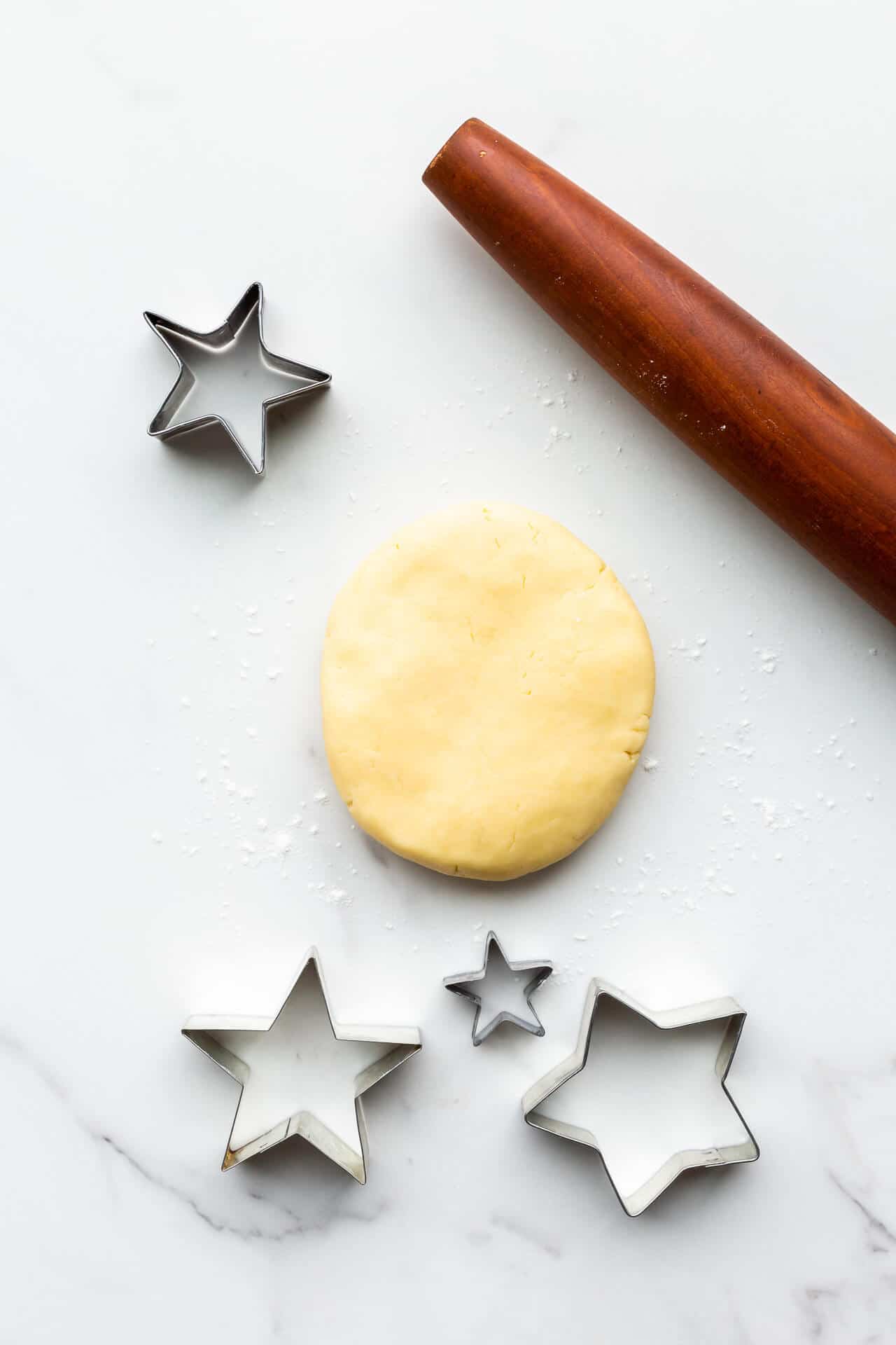 Shortbread dough with rolling pin and cookie cutters ready to be rolled and cut to bake them.