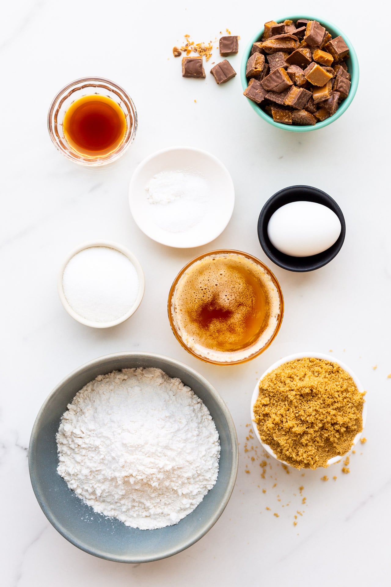 Ingredients measured out to make Skor cookie bars, with browned butter, dark brown sugar, vanilla, an egg, leaveners, salt, flour, and lots of chopped Skor bars