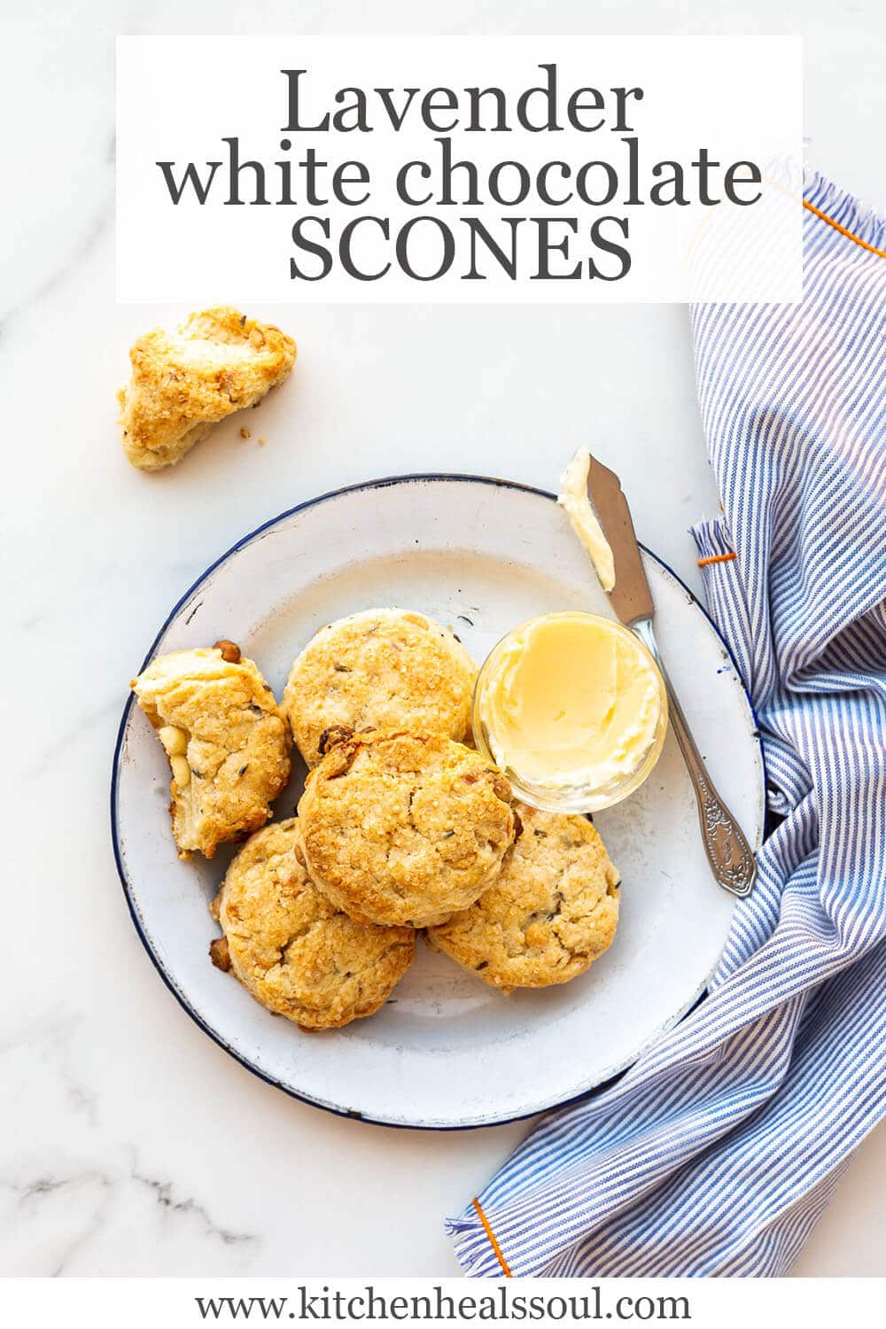 Baked lavender white chocolate scones on a blue-rimmed white enamelware plate with butter and a butter knife, blue and white striped napkin