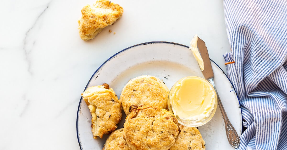 Plate of scones served with butter and butter knife and striped napkin