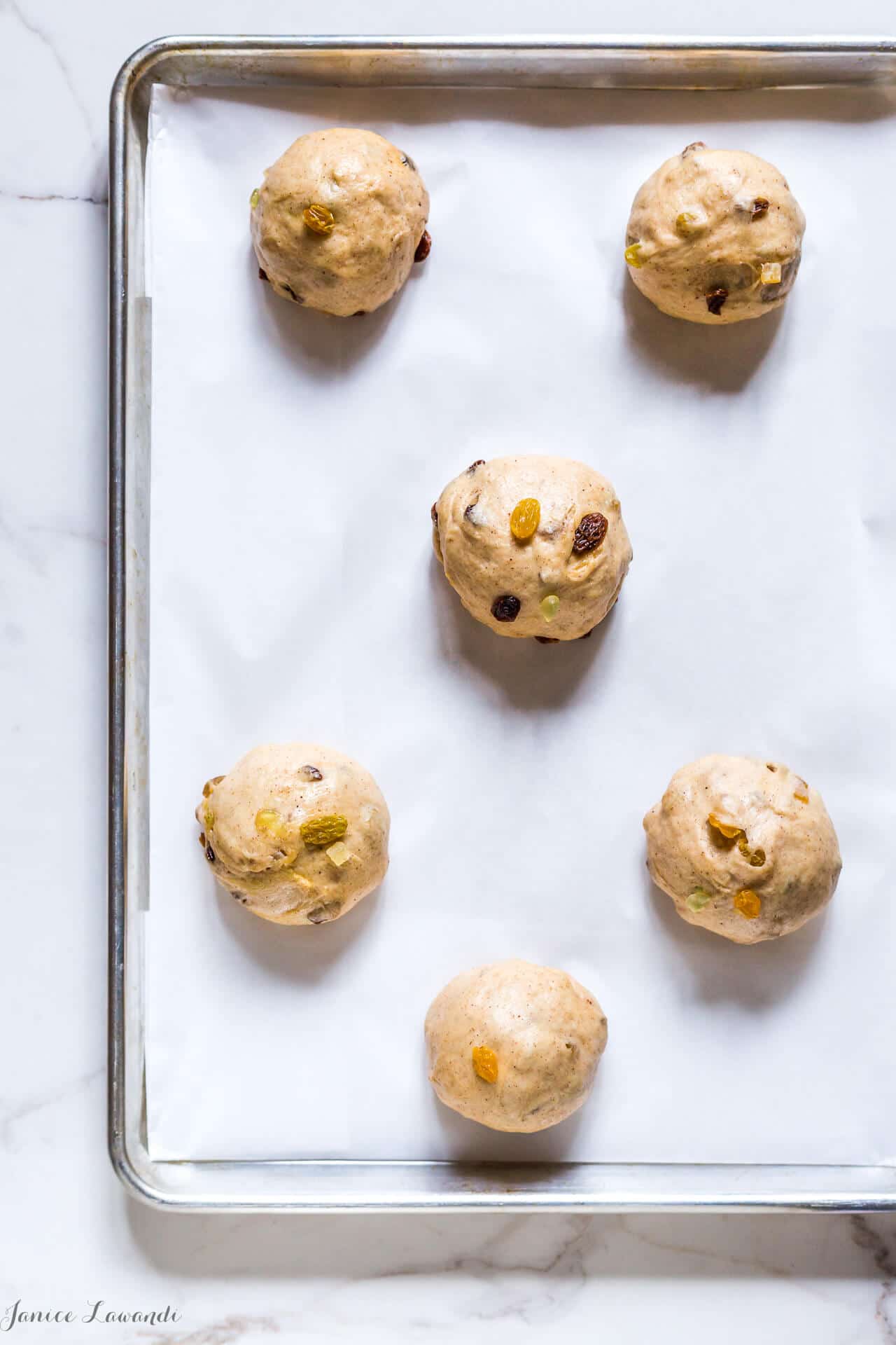 Traditional hot cross buns dough is shaped into buns before rising a second time.