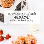 A basket of strawberry rhubarb muffins with crumble topping with a glass of milk and a muffin sliced open with fresh strawberries