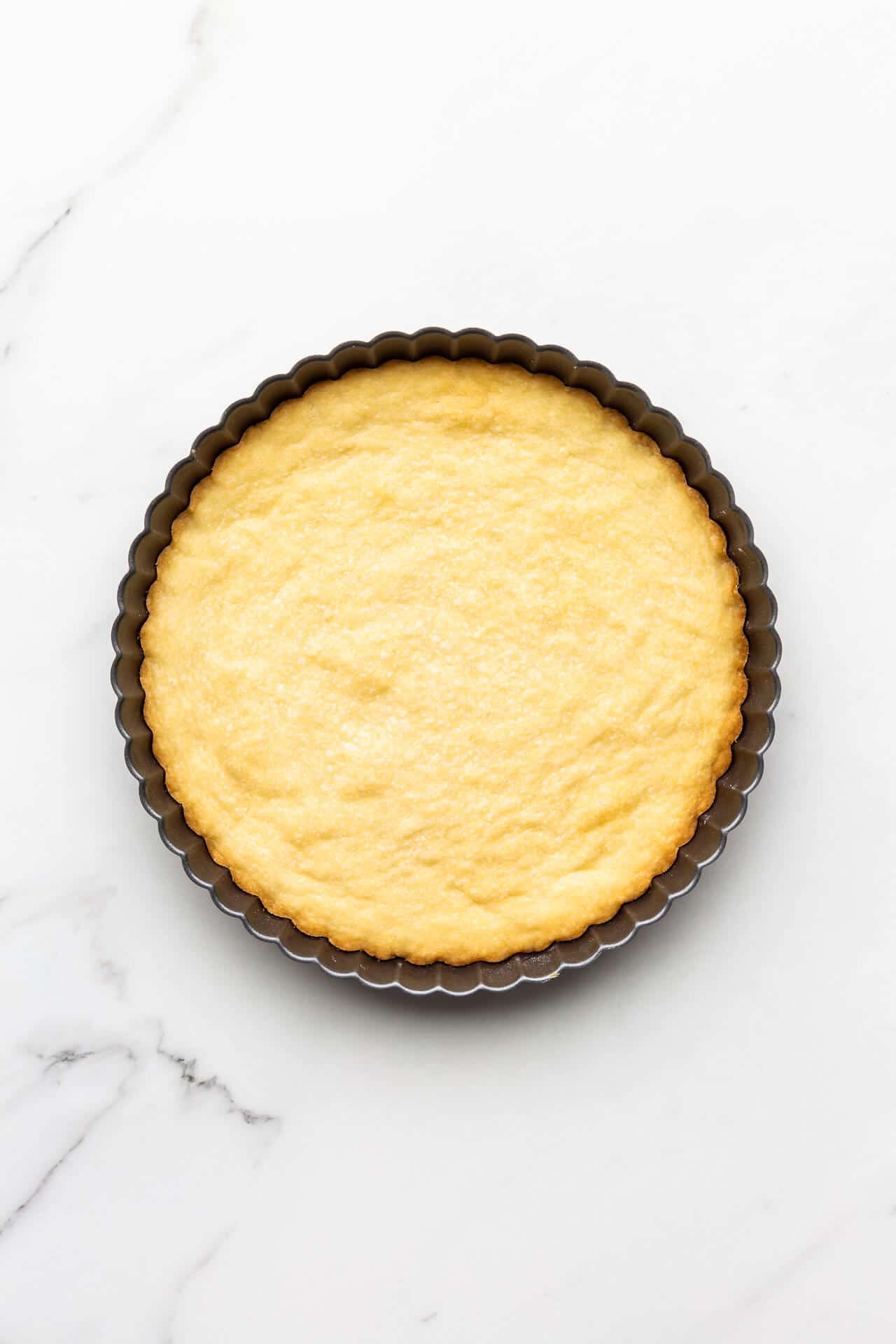 Freshly baked shortbread cookie baked in a fluted tart pan for a crinkly edge