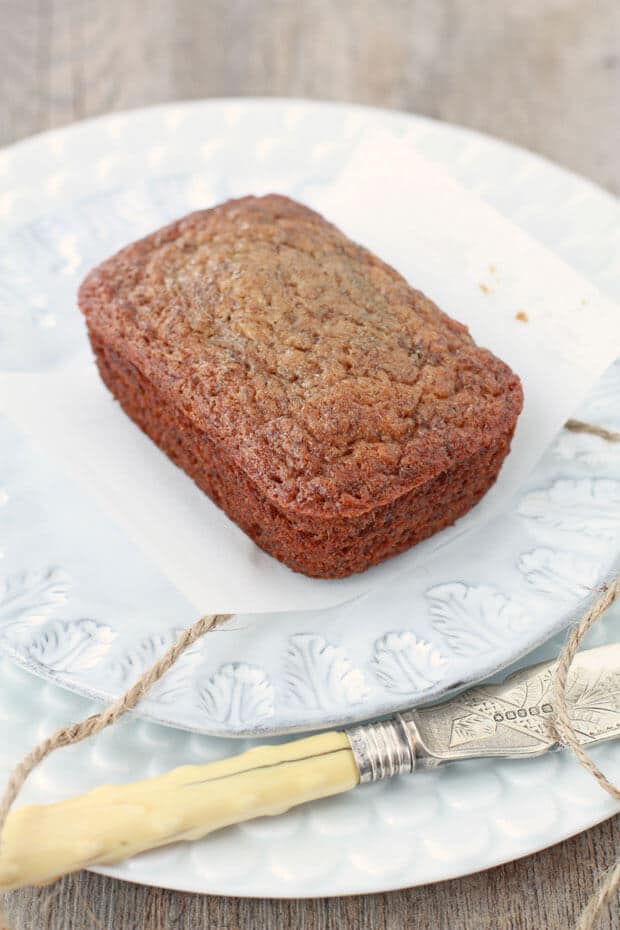 Mini cardamom banana bread served on a light blue ceramic plate with a knife