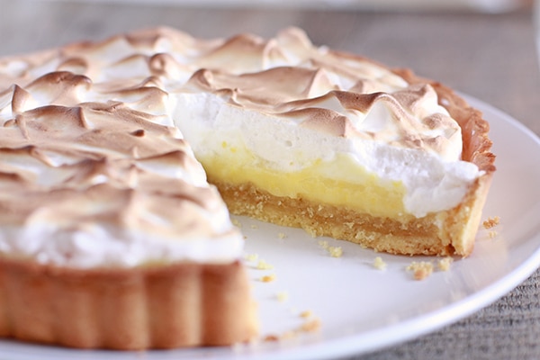 French tarte au citron made with a pâte sucrée, a layer of frangipane, a layer of lemon curd, and then topped with Italian meringue, then torched.