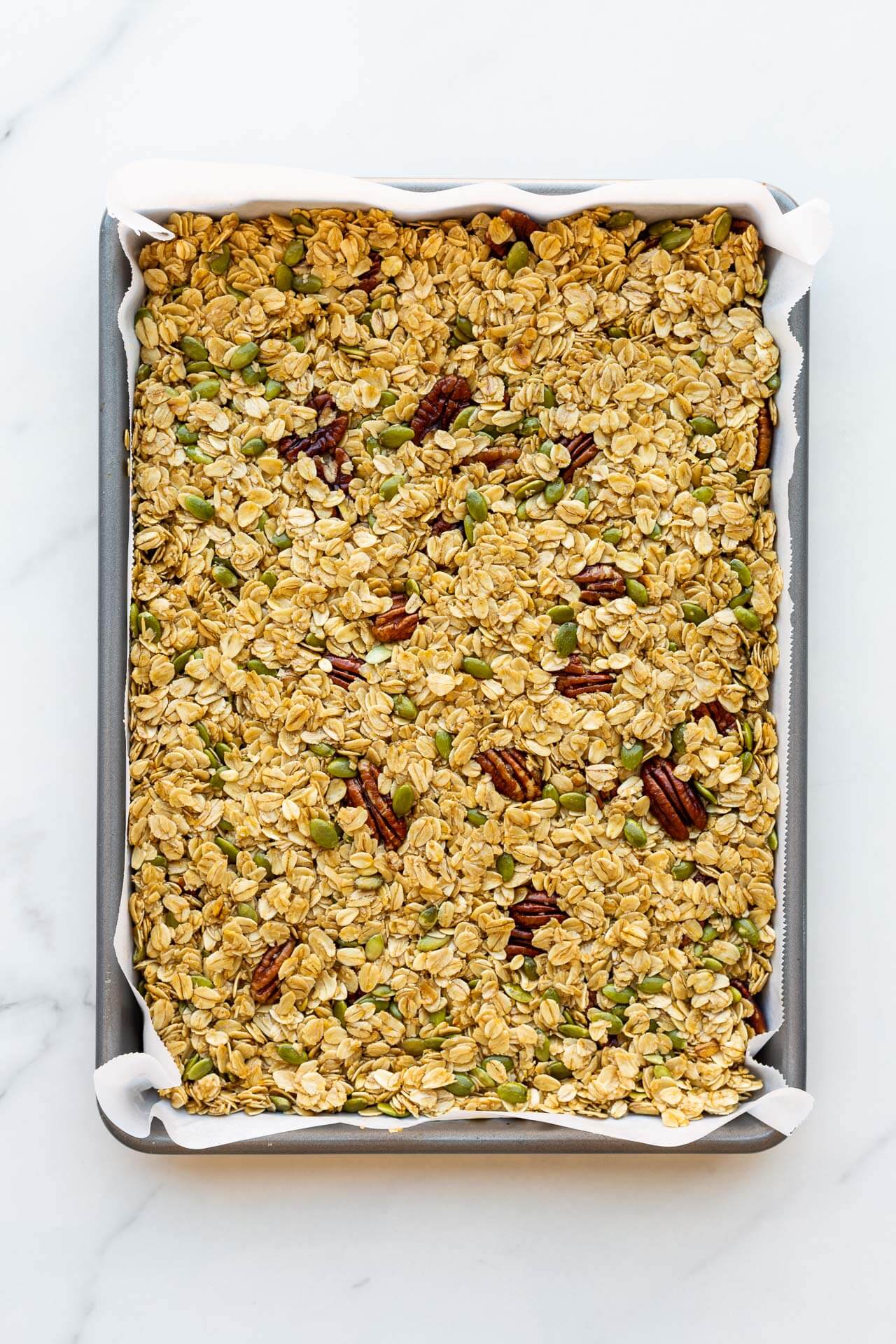 Granola mixture pressed in a sheet pan