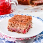 A piece of gluten-free raspberry cake served with a raspberry coulis.