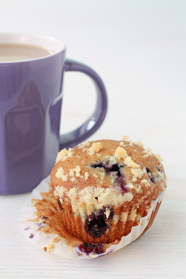 Honey blueberry muffins with a crumble topping served with a purple mug of tea