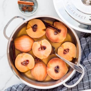 Poached quince cut in half in a sauté pan with simple syrup.