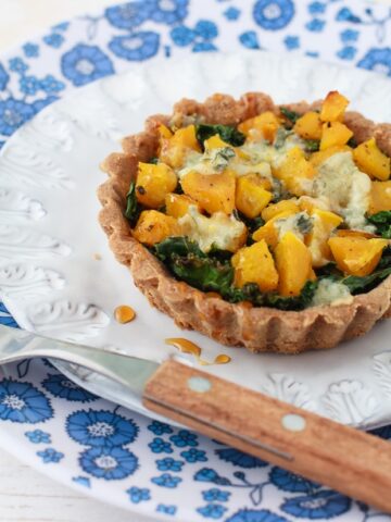 gluten-free tarts filled with kale, squash and topped with cheese
