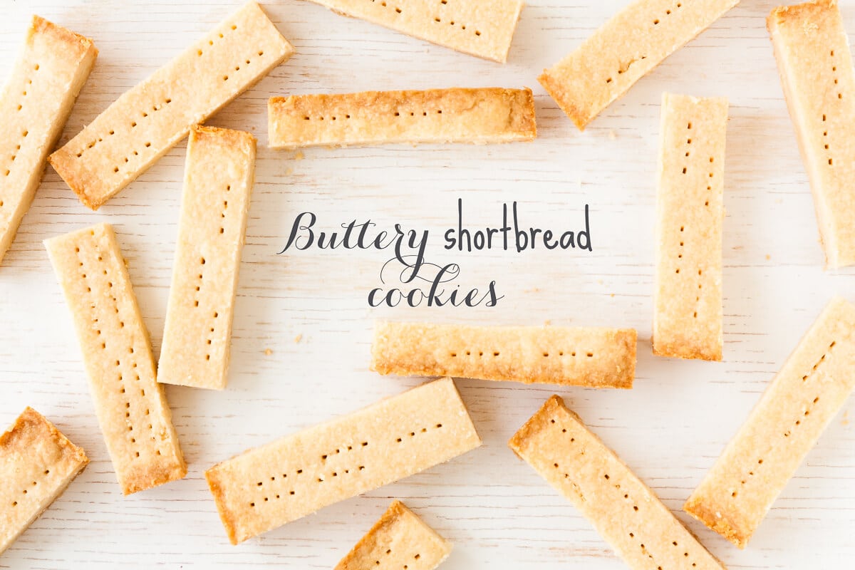 Buttery Shortbread cookies cut into bars like walker shortbread and arranged on a white-washed wood surface