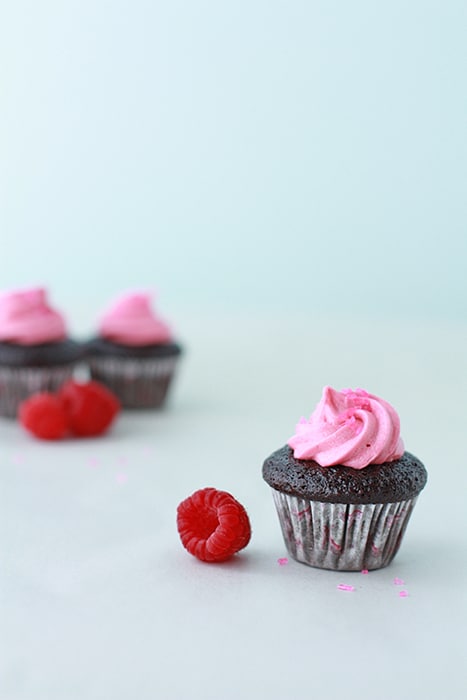 mini chocolate cupcakes with raspberry frosting and fresh raspberries