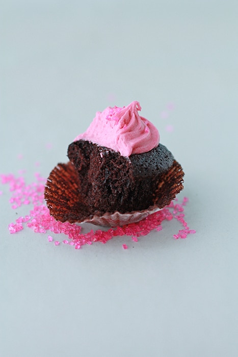 half a mini chocolate cupcakes with raspberry frosting to show moist crumb of cupcake