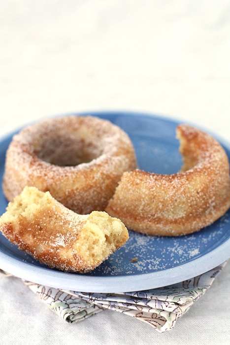 baked sour cream doughnuts broken open on a blue plate