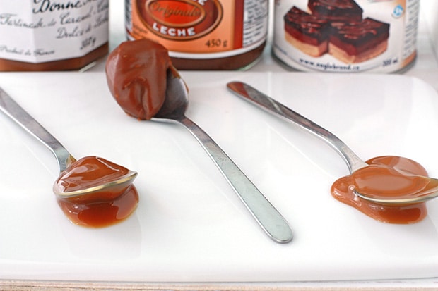 Three spoons of three different store-bought dulce de leches to compare thickness, texture and colour.