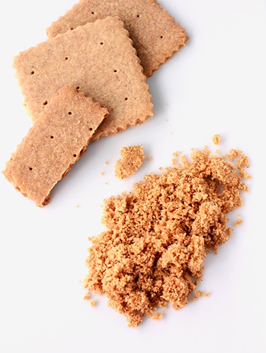 Homemade graham crackers with scalloped crinkle edges ground into homemade graham cracker crumbs