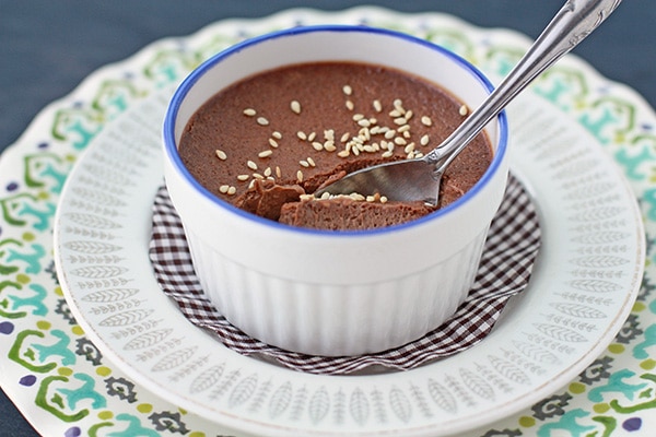 chocolate sesame pots de crème in a ramekin with a blue rim set on plates