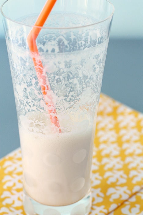 banana coffee shake in a tall glass, half drunk with orange straw