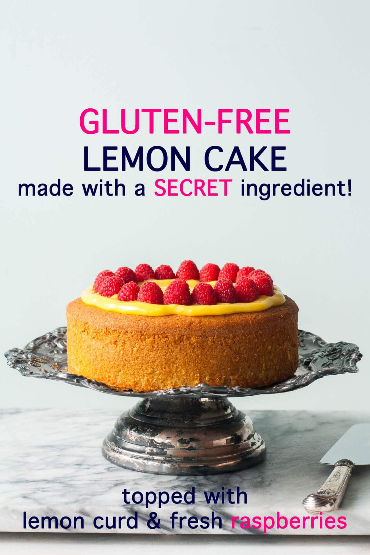 Single layer gluten-free lemon cake topped with homemade lemon curd and fresh raspberries served on a tarnished antique cake stand