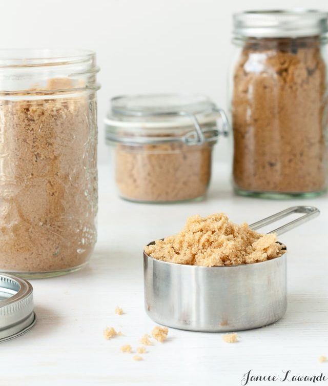 Jars of brown sugar and brown sugar in a dry measuring cup