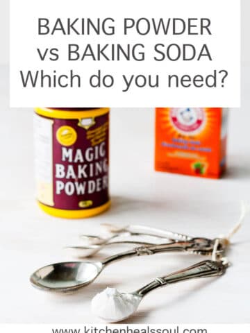 A box of baking soda and a container of Magic baking powder with a set of measuring spoons for scooping these chemical leaveners