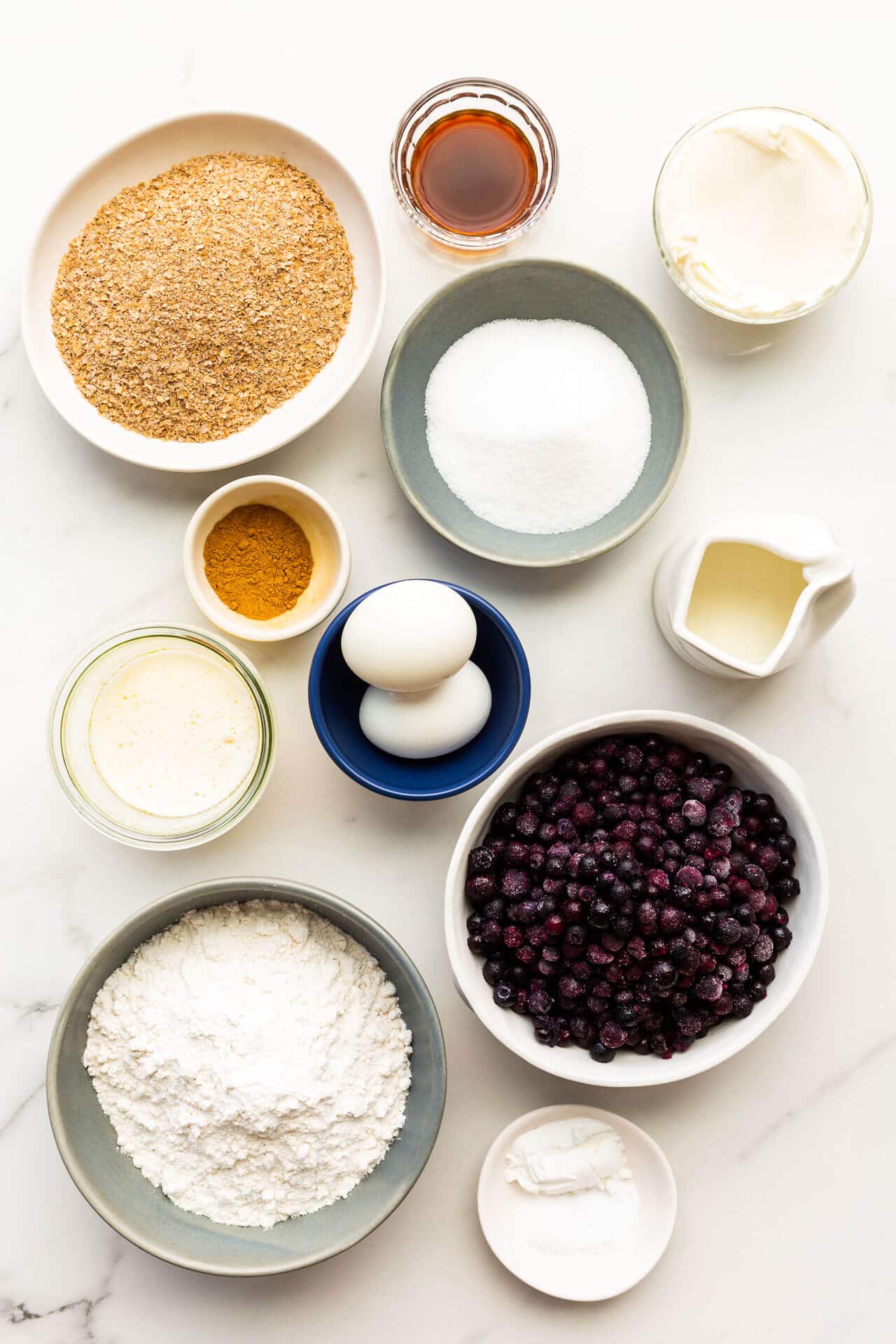 Ingredients to make blueberry bran muffins measured out into bowls, ready for mixing