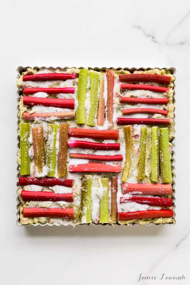 Rhubarb cake before baking to show how rhubarb is arranged in a pattern like it's woven