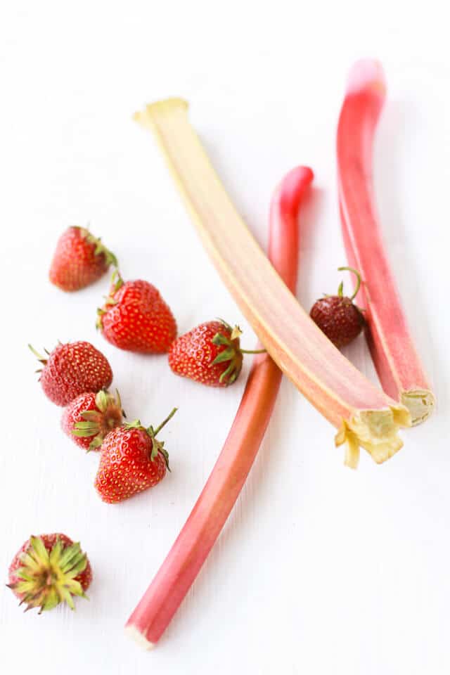 Stalks of fresh rhubarb and strawberries with the stems on