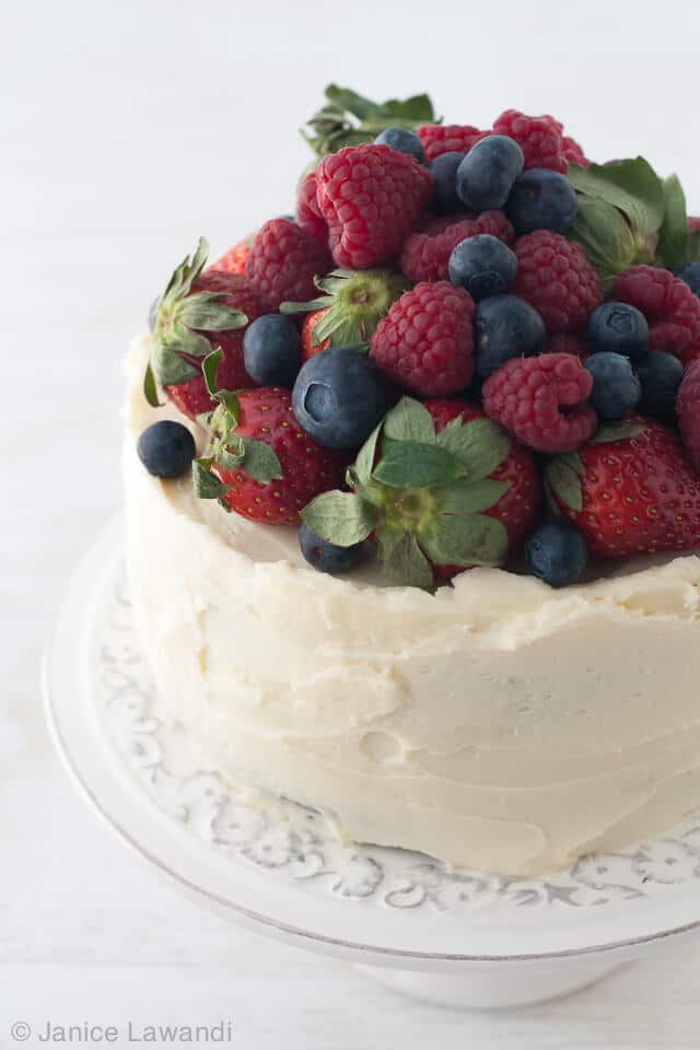 Chocolate cake with cream cheese frosting and topped with berries.