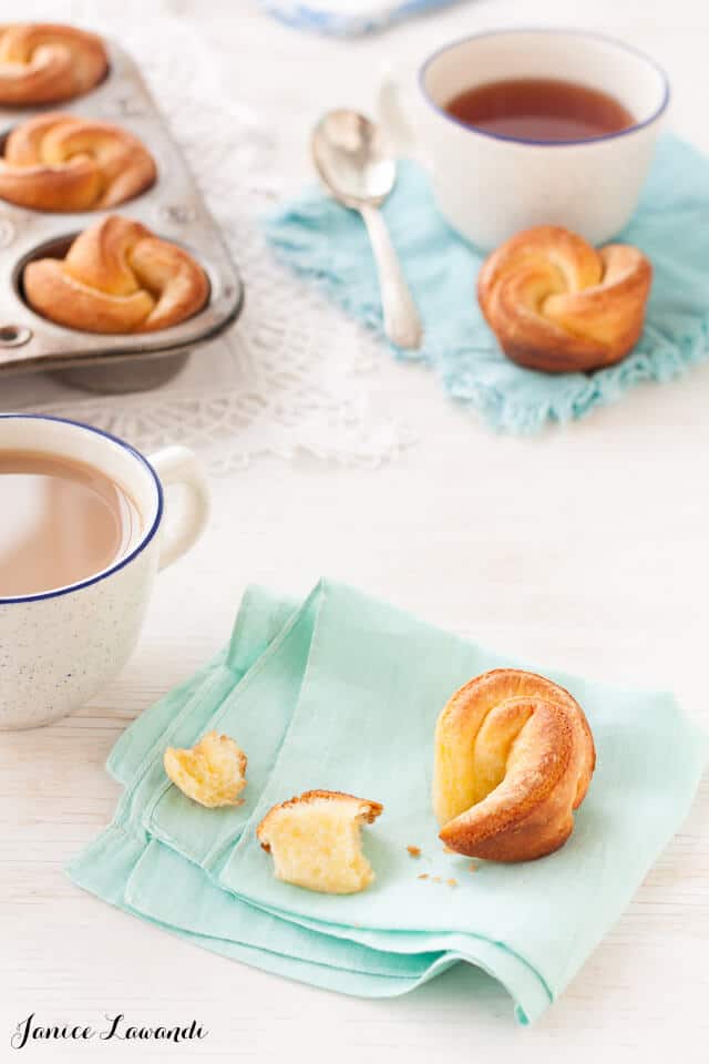 maple brioche buns shaped like flowers on turquoise napkins served with cups of tea