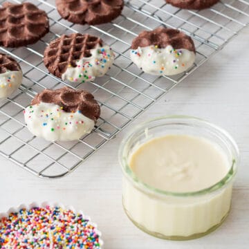 Dipping chocolate cookies in white chocolate and sprinkles