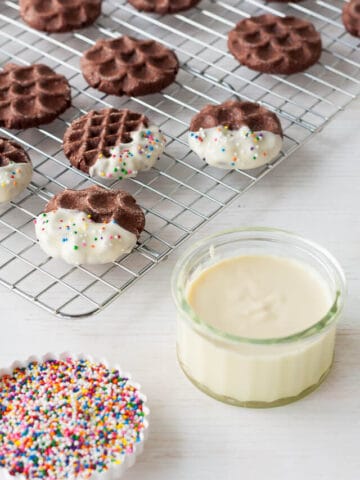 Dipping chocolate cookies in white chocolate and sprinkles