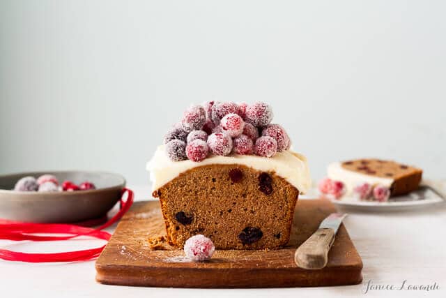 Frosted cranberry chestnut loaf cake with rum frosting and sugared cranberries on top