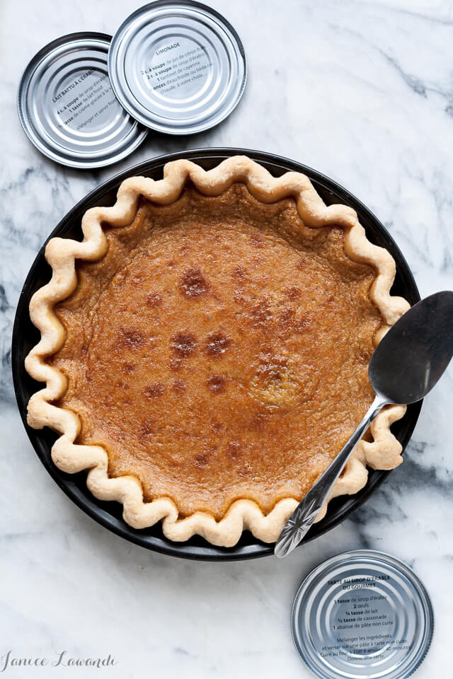 Maple syrup custard pie baked in a dark metal pie pan with pie server