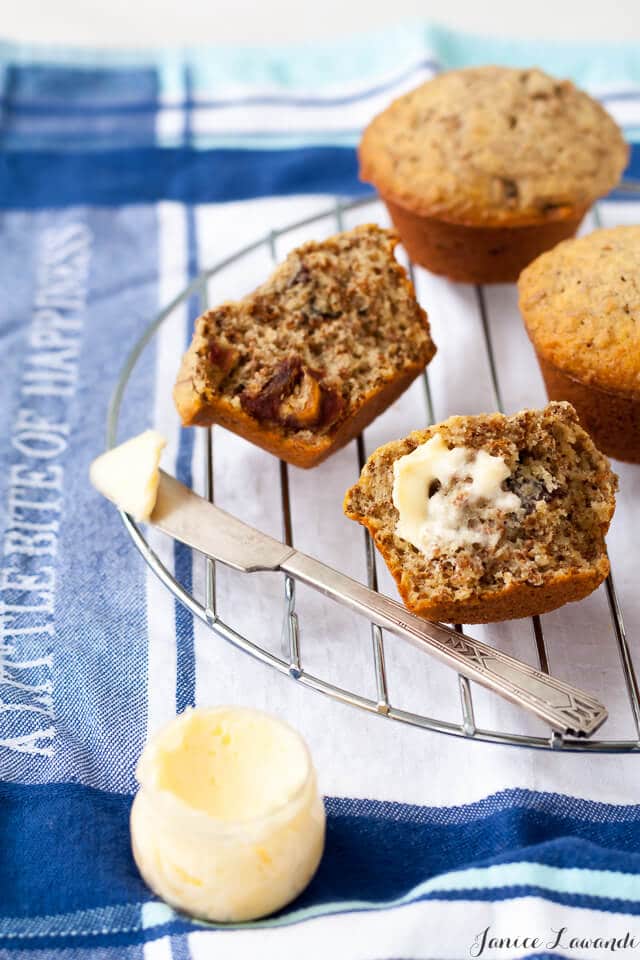 date bran muffins on a cooling rack and butter with a butter knife