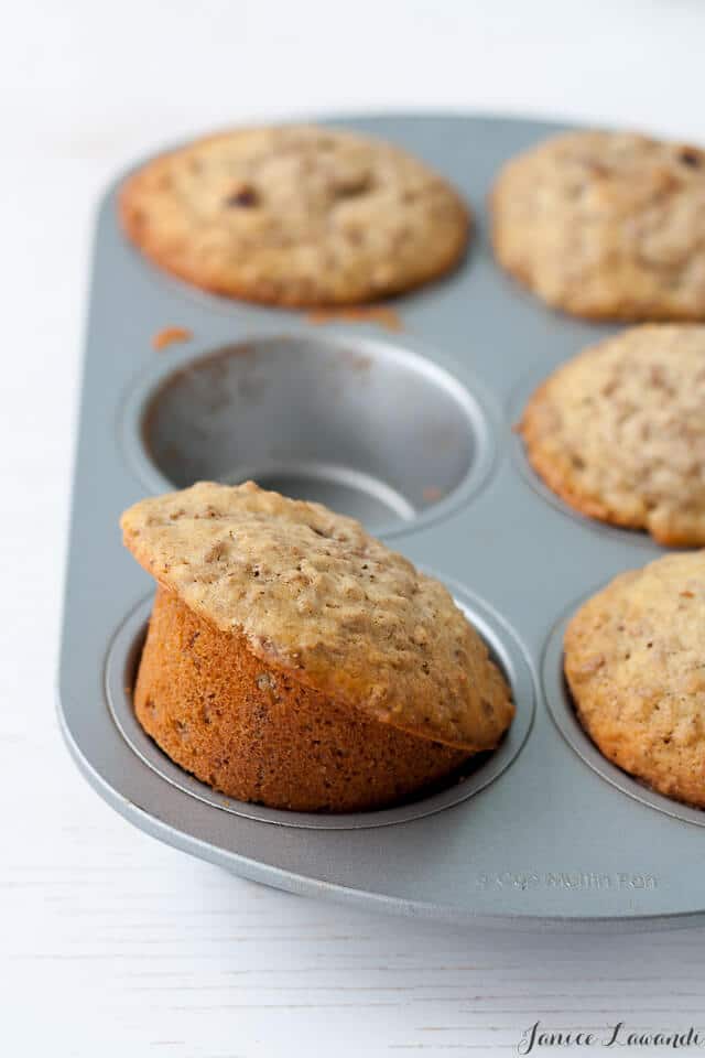 homemade date bran muffins in a muffin pan with 1 cup empty