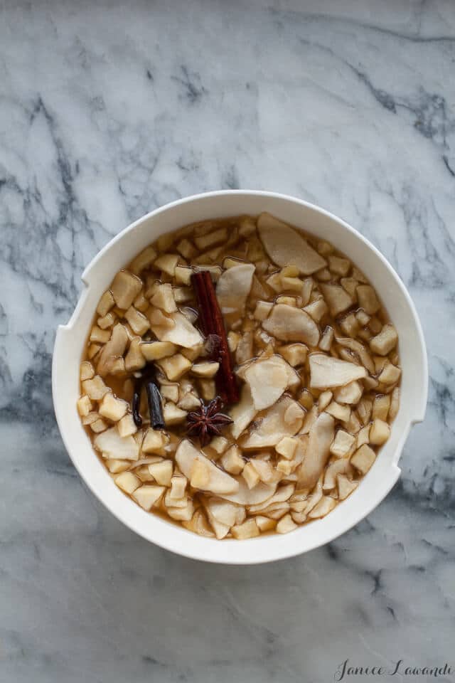 Macerating apples in a big bowl with sugar and spices to make apple jam in