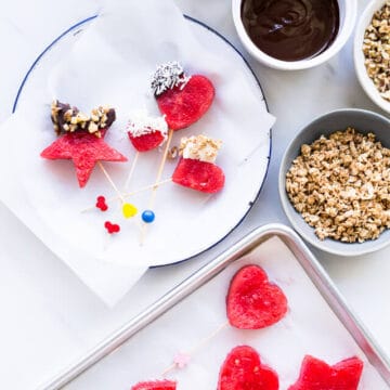 Frozen watermelon pops dipped into melted chocolate and granola or other fun toppings