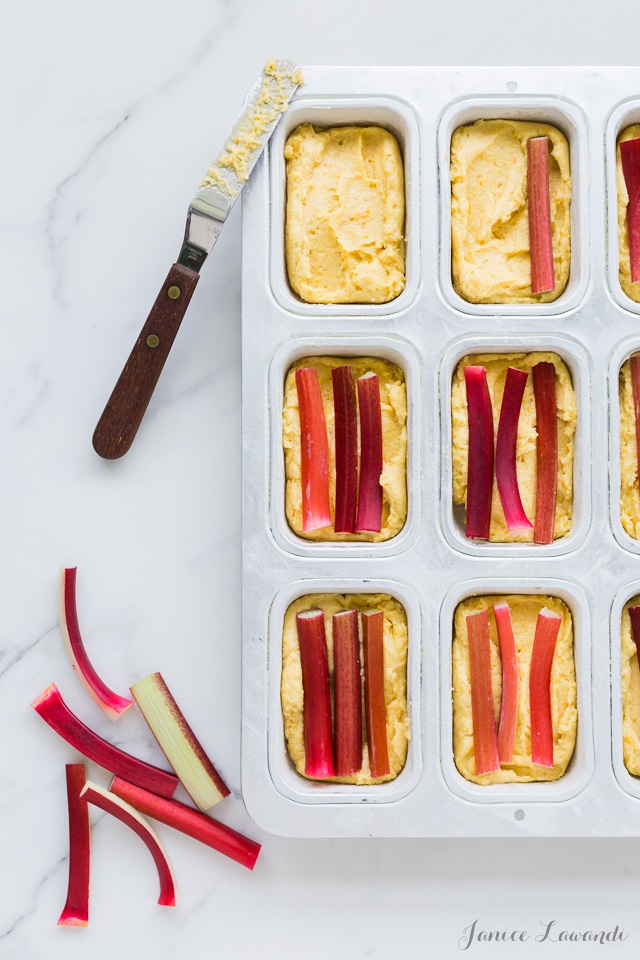 Placing long pieces of rhubarb to make orange rhubarb cakes with cornmeal