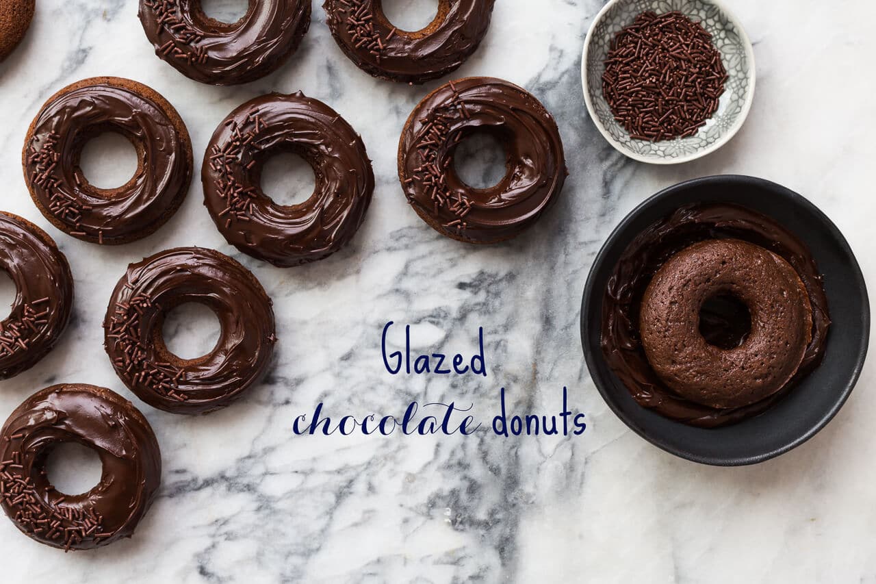 Glazed Chocolate Donuts that are baked donuts, not fried, dipped in a ganache glaze and topped with chocolate sprinkles