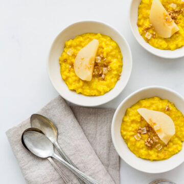 Golden milk rice pudding spiced with turmeric, ginger, cardamom, and cinnamon served with poached pears