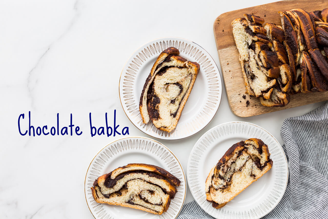 Chocolate swirl babka loaf sliced on a wooden cutting board