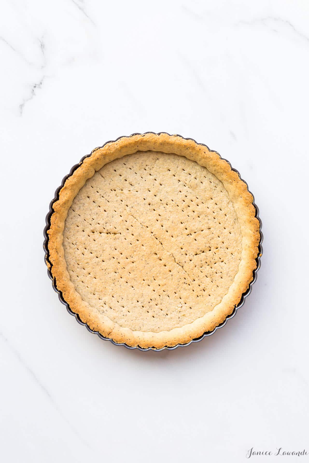 Blind baked sablé cookie crust with fork marks for venting steam