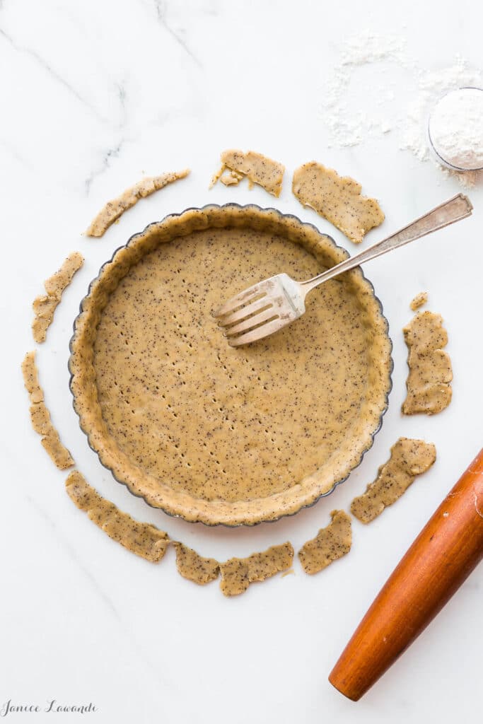 Coffee sablé cookie crust - the raw crust is being docked (pricked) with a fork to allow steam/air to vent during baking. The crust will be blind baked