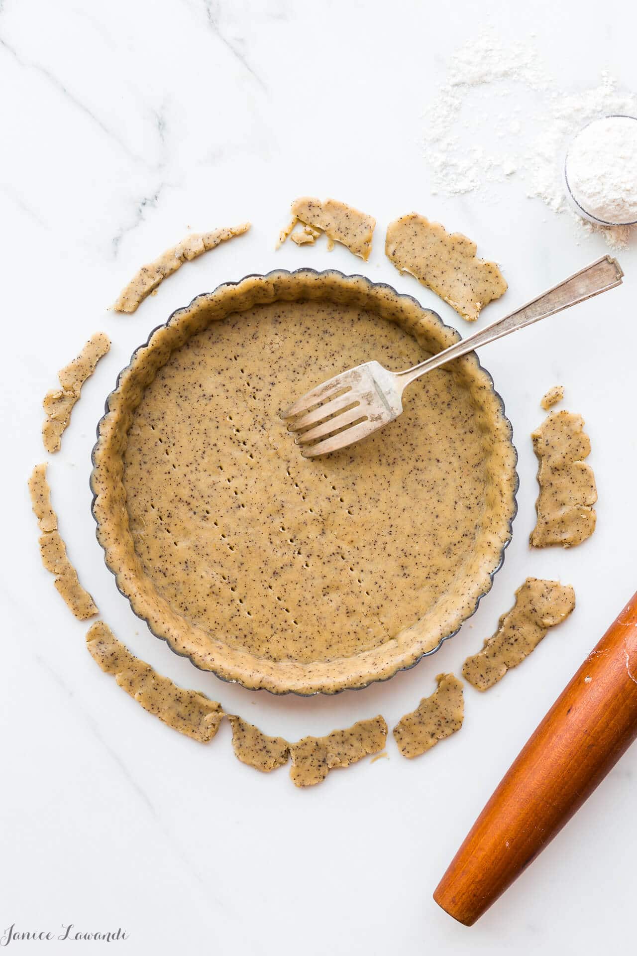 Coffee sablé cookie crust - the raw crust is being docked (pricked) with a fork to allow steam/air to vent during baking. The crust will be blind baked