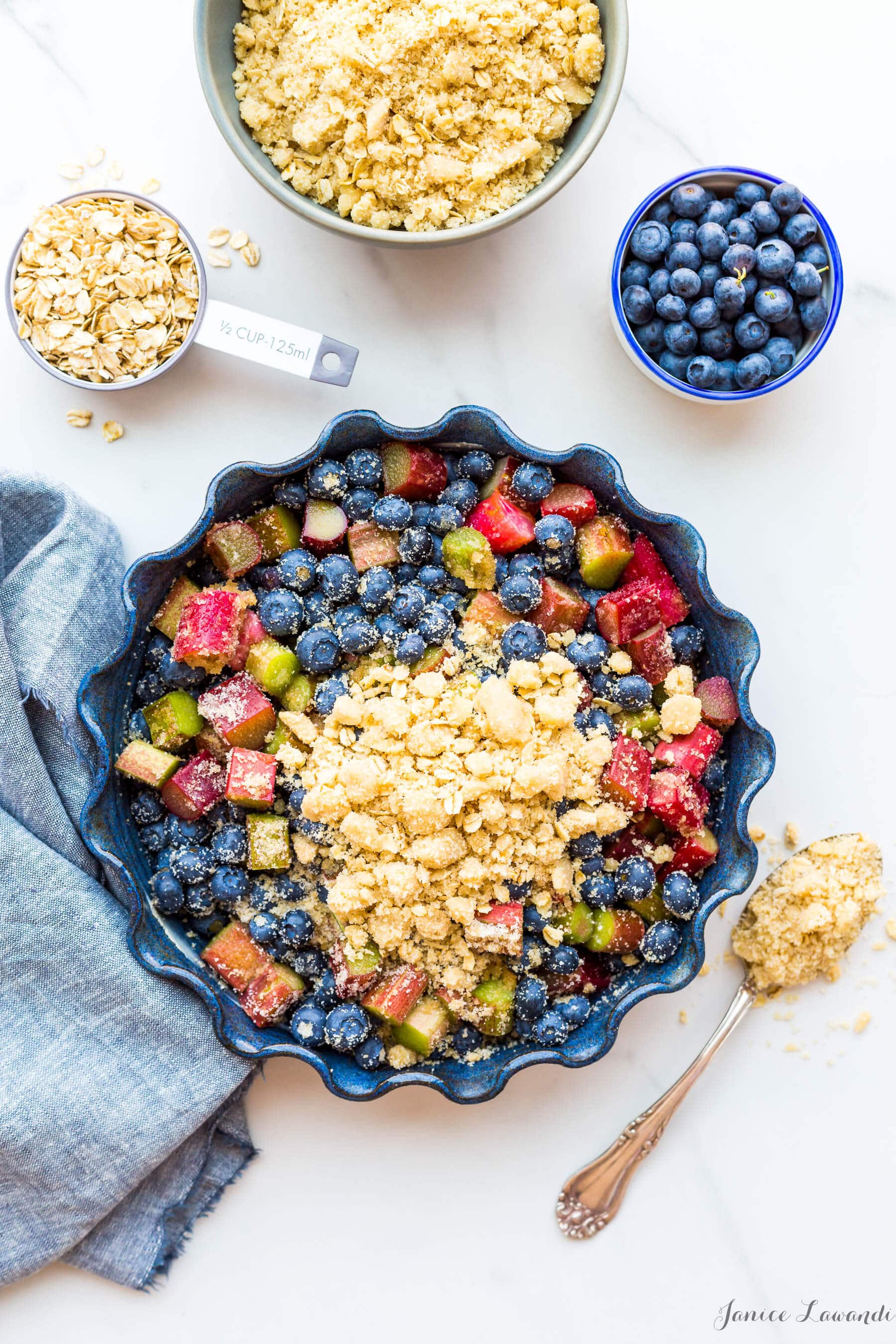 Topping a mixture of blueberry and rhubarb with a marzipan oat crumble topping to make a blueberry rhubarb crisp